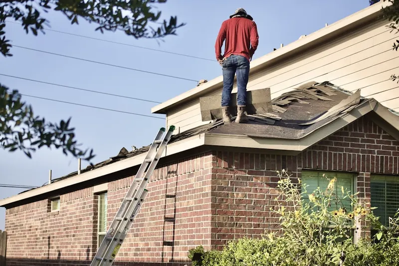 Professional roofer working on a residential roof in Rismiller